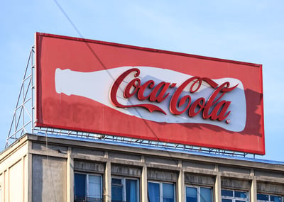 Cartel publicitario con anuncio de cocacola exterior es outbound marketing